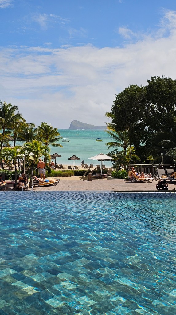 Zilwa attitude Resort swimming pool overlooking palm trees and the sea in Mauritius