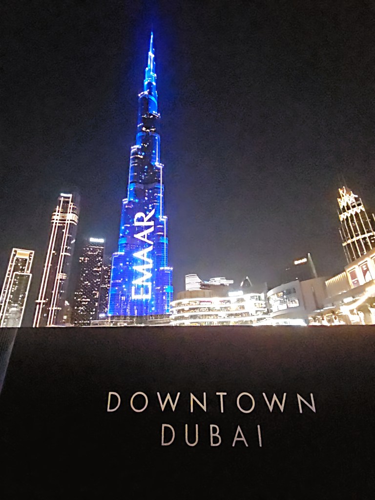 Burj Khalifa lit up at night in downtown Dubai with surrounding city lights