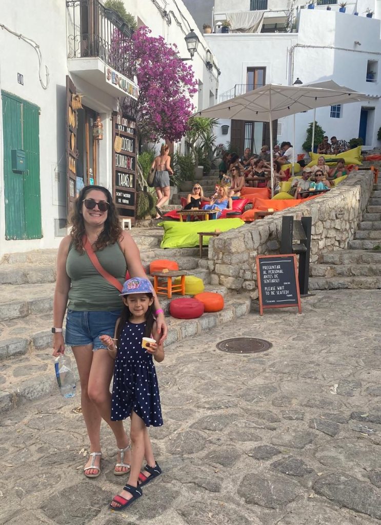 Adult and child walking along stone steps lined with cafes in Ibiza town